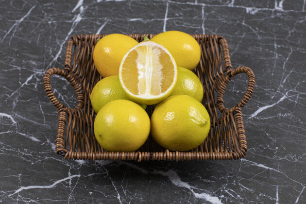 新鲜新鲜的酸柠檬放在木篮里酸有机健康