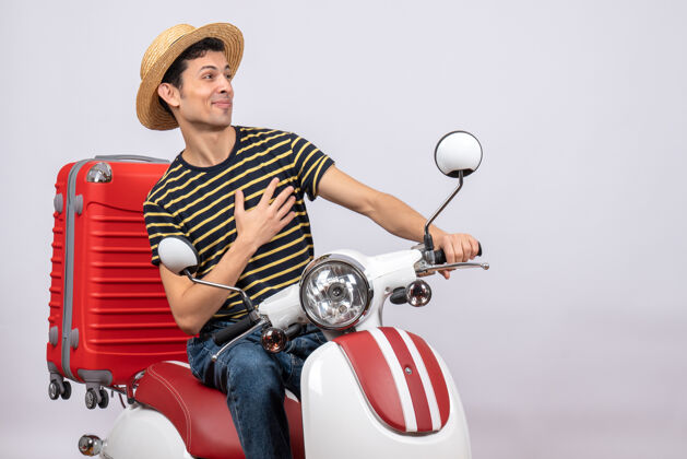 帽子前视图满意的年轻人 戴着草帽 手放在胸前前面稻草摩托车