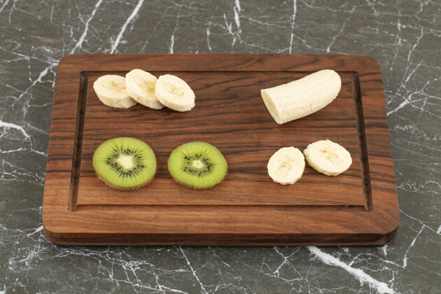 香蕉把猕猴桃和香蕉片放在木板上素食新鲜甜点
