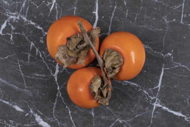 天然成熟的柿子果实放在大理石上半熟美食有机