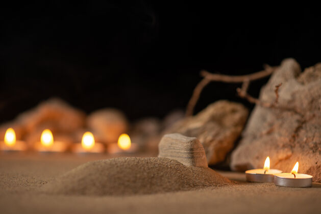 夜晚在小坟周围用石头点燃蜡烛 纪念葬礼上的死亡葬礼蜡烛坟墓
