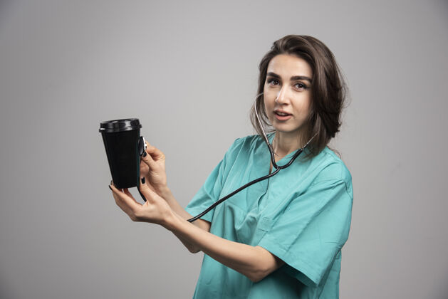 工作女医生用听诊器检查咖啡杯高质量照片妇女听诊器医院
