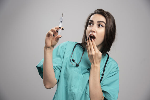 注射器穿制服的女医生害怕注射器高质量的照片听诊器女性医院