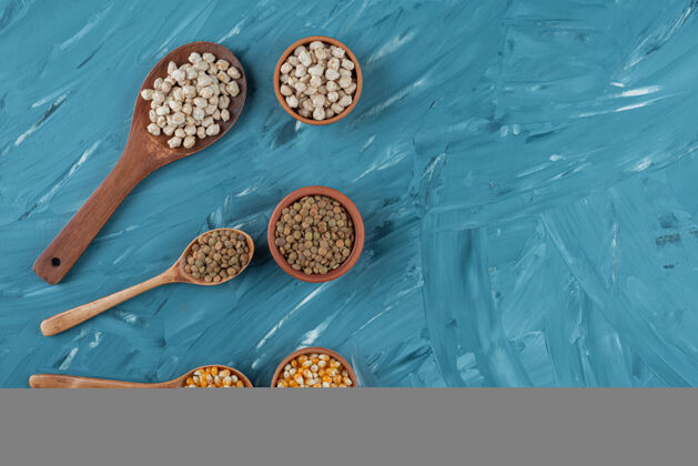 食品三碗生玉米 鹰嘴豆和荞麦放在蓝色的表面上营养杂货玉米