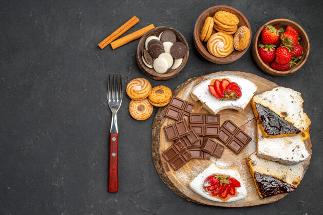 餐厅在黑色的桌子上俯瞰蛋糕片和饼干和巧克力饼干水果正餐