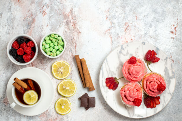 晚餐粉红色草莓蛋糕的俯视图 白色表面上有果酱和茶装饰餐厅杯子
