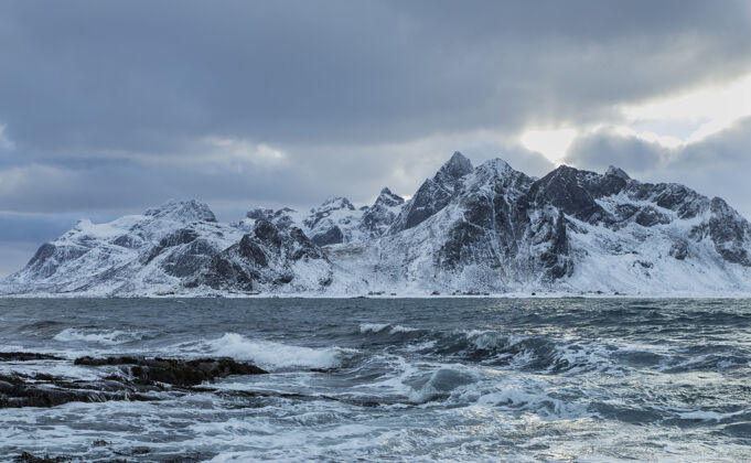 冬天一个美丽的拍摄海浪与雪山的背景雪景色冰