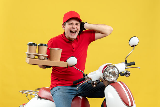 前面前视图紧张的信使男子穿着红色上衣 戴着帽子手套 戴着医用口罩 坐在滑板车上拿着命令 闭上耳朵红色医疗摩托车