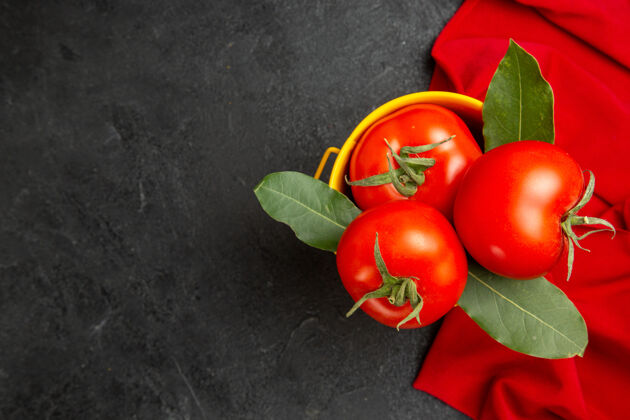 成熟顶视图一桶西红柿和月桂叶放在红毛巾上黑暗的地面上新鲜深色素食