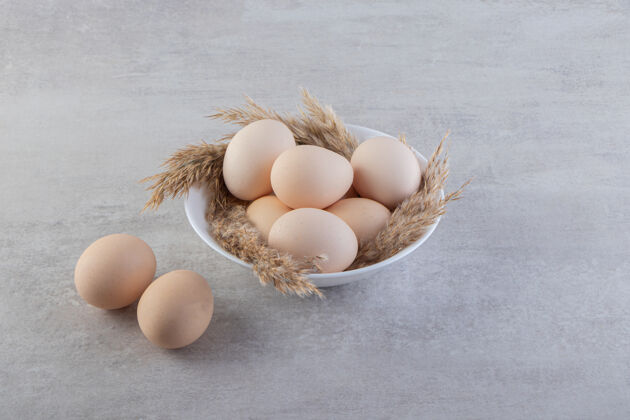 未经料理的把新鲜的生鸡蛋放在石头上食物生的鸡肉