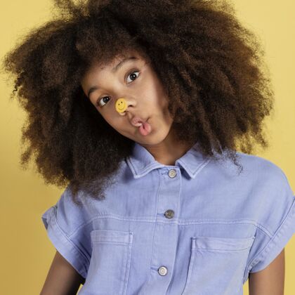 年轻年轻可爱的女孩与表情贴纸摆姿势的肖像非洲天真贴纸