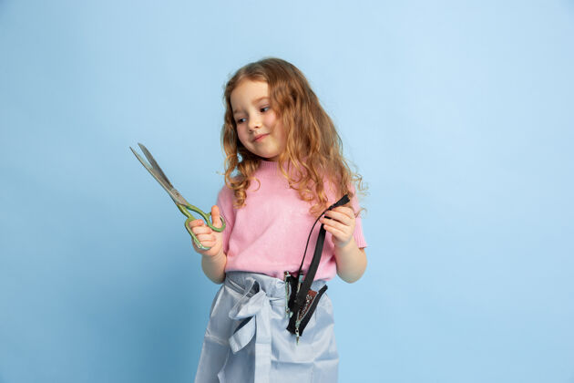 人小女孩梦想着未来的裁缝职业表演童年行动
