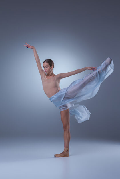当代芭蕾舞美丽的芭蕾舞演员在蓝色的背景上 戴着蓝色的面纱跳舞舞蹈年轻女孩