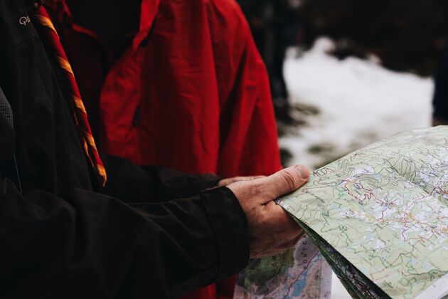 旅游两个人在雪地里拿着地图看地图的特写镜头道路背景冬天