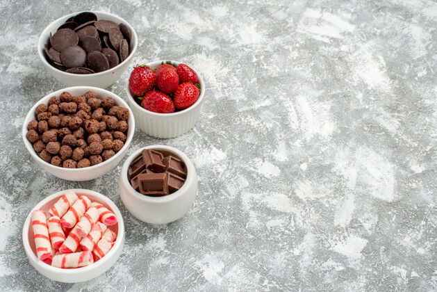 水果左上角 灰白色地面上有白色 红色糖果 草莓 巧克力 谷类食品和可可食物美味覆盆子