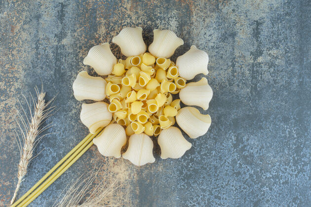 美食用意大利面和麦穗做成的花 在大理石背景上风味意大利面美味