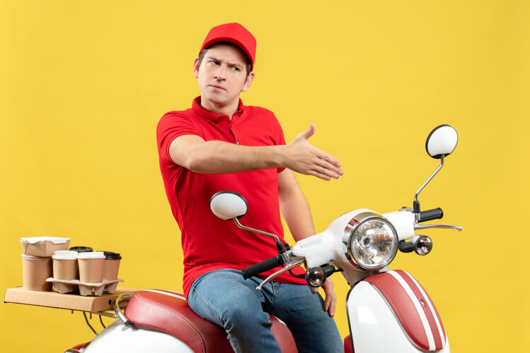 某人俯视图：不满意的年轻人穿着红色上衣 戴着帽子 在黄色的墙上欢迎某人传送带运动帽子