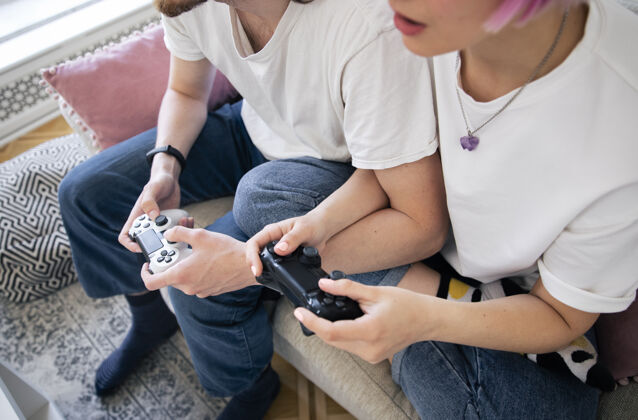男人可爱的情侣在沙发上玩电子游戏虚拟玩家视频游戏