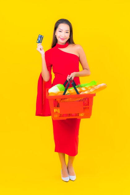 微笑从超级市场拿着购物篮的美丽亚洲年轻女子的画像消费者超市肖像