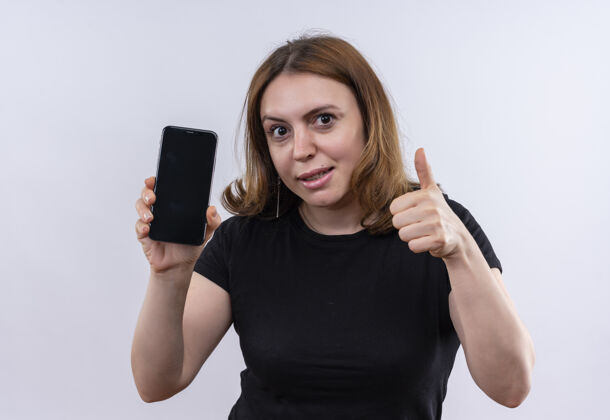 显示印象深刻的年轻休闲女子手持手机 并显示拇指上孤立的白色空间电话印象手机