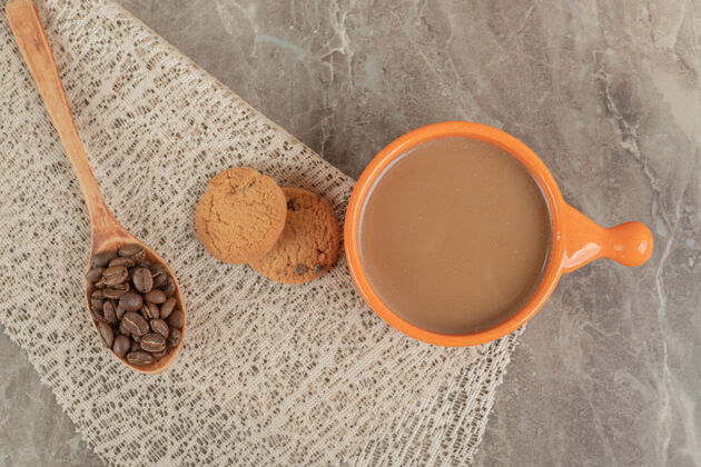 咖啡一杯咖啡 饼干放在大理石表面 上面放着咖啡豆营养烤饼干