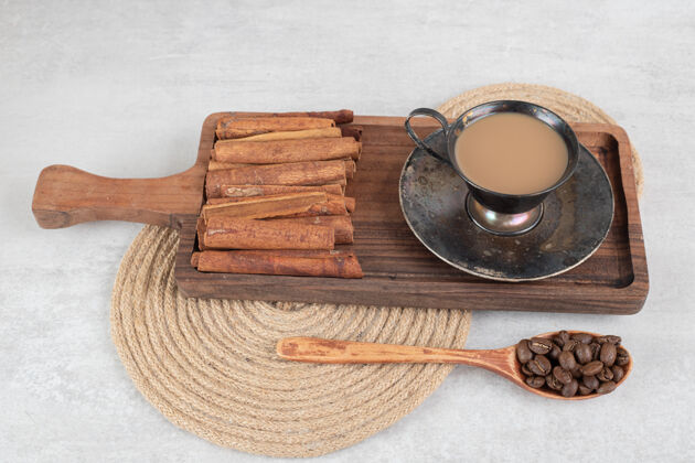 马克杯一杯咖啡 肉桂棒放在深色的木板上 咖啡豆香味热的配料