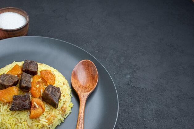 米饭正面图美味的肉片米饭和盐在黑暗的表面切片卧式晚餐