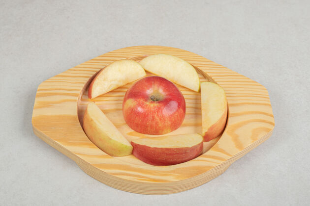 切片把一整片红苹果放在木盘上配料一餐生的