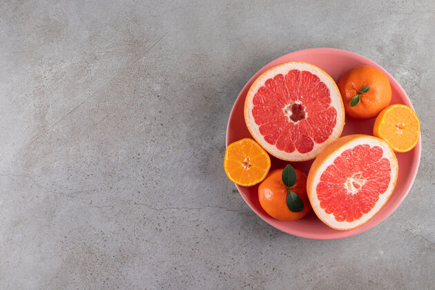 饮食把橘子片和柚子片放在粉红色的碗里生美味切割