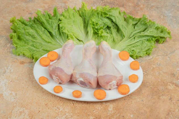 鸟一盘白白的鸡腿配生菜和胡萝卜片生的盘子健康