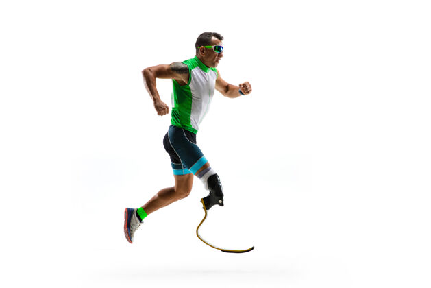 运动残疾运动员或截肢者隔离在白色工作室背景下专业男性跑步者 带假肢 在工作室训练和练习残疾运动和健活方式理念医疗人造膝盖