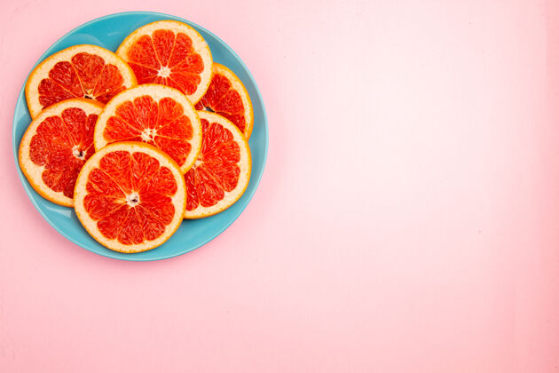 盘子美味的葡萄柚水果片在粉红色表面盘子内俯视图醇香里面水果