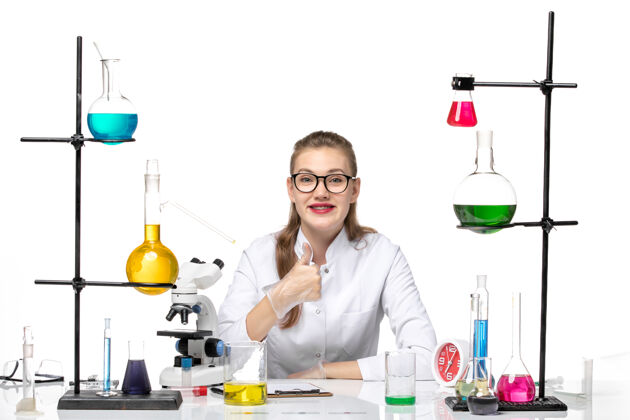 实验室前视图穿着医疗服的女化学家坐在白色背景上微笑着解决方案大流行化学冠状病毒人竖起大拇指女化学家