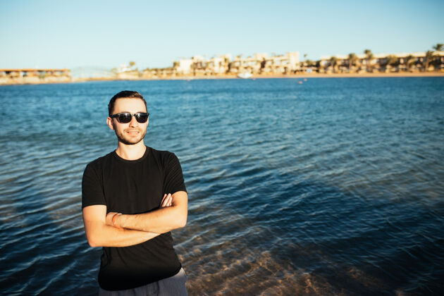 太阳镜年轻帅哥戴着眼镜在海边玩前面一个休闲