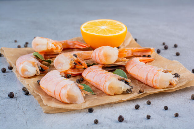 烹饪美味的虾片柠檬和胡椒粉在防油纸上海洋海鲜欧芹
