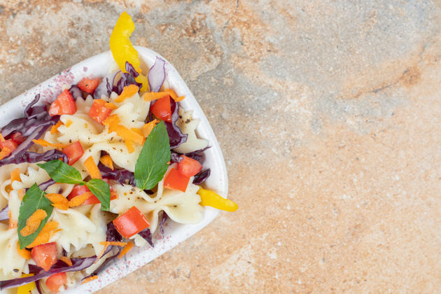 香草在大理石表面的碗里放不同的蔬菜和意大利面营养面食烹饪
