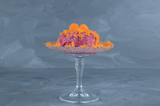 甜菜大理石桌上有一个小玻璃底座 上面放着适量的胡萝卜胡桃和甜菜沙拉美味装饰美味