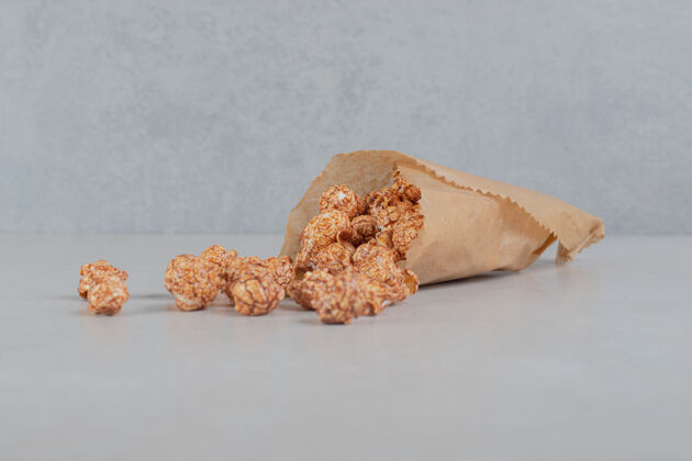 美味大理石桌上装满糖果的爆米花的纸包装爆米花糖包装