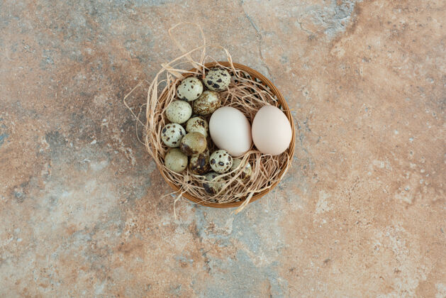 天然大理石桌上放满了装鹌鹑蛋的柳条篮子篮子饮食鸡肉