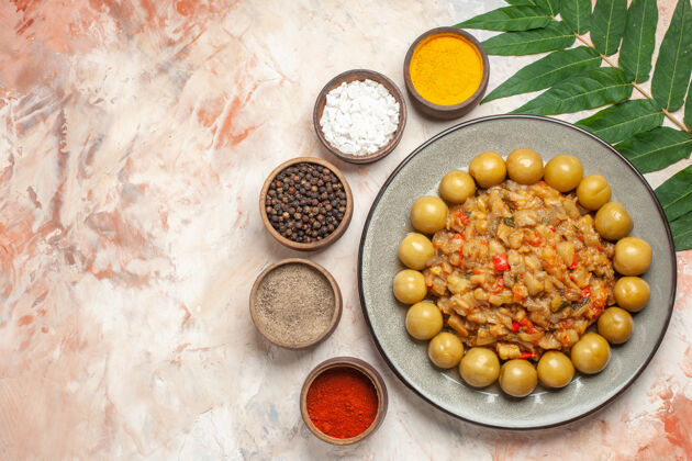 农产品顶视图烤茄子沙拉在盘子里不同的香料在小碗叶子在裸体表面素食碗健康