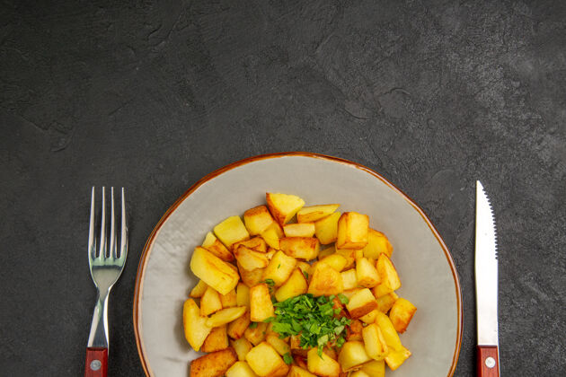 谷物美味的炸土豆在黑暗的表面与绿色盘子里俯瞰绿色果仁薯条