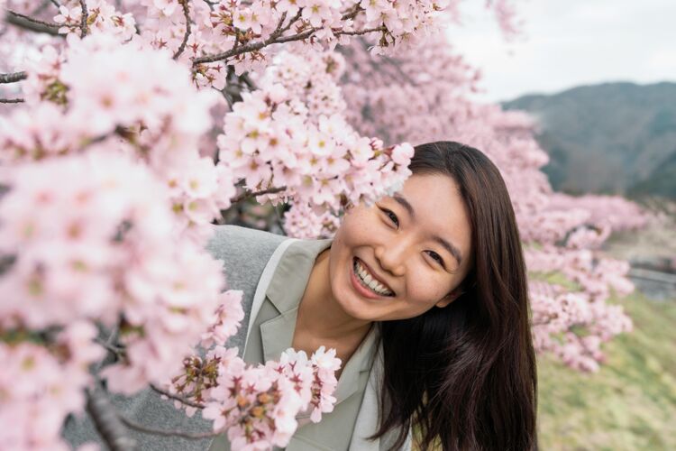 美丽年轻女子欣赏周围的自然自然樱花日本
