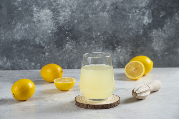 餐桌在木板上放一杯新鲜的柠檬汁柑橘柠檬水鸡尾酒