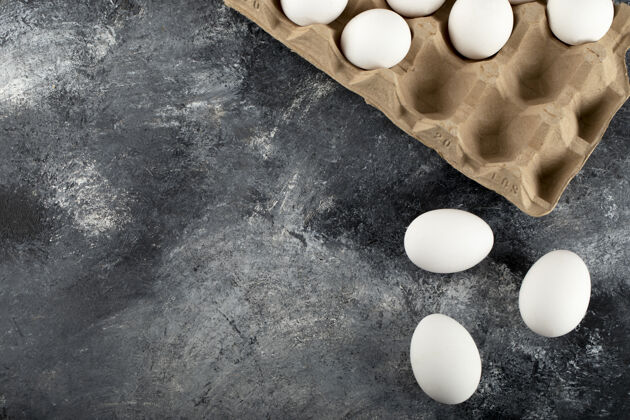 食品生鸡蛋放在大理石表面的鸡蛋盒里生的鸡蛋纸箱组