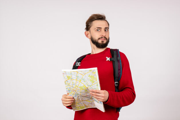 情感正面观看带背包的年轻男性游客在白墙平面城市度假情感人文路线探索地图男人成人颜色