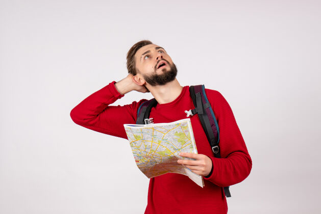 飞机正面图年轻男性游客背着背包在白墙上探索地图飞机城市度假情感人文旅游情感颜色城市