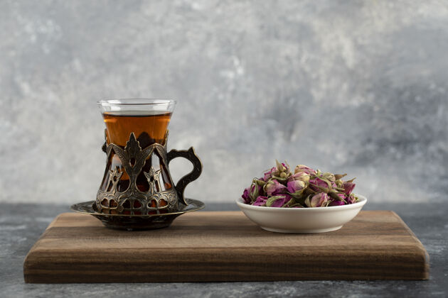 药一杯热茶 放在木制砧板上 上面放着干玫瑰热的芳香的桌子