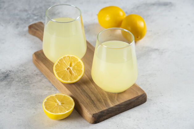 新鲜的在木板上放两杯新鲜的柠檬水玻璃水鸡尾酒