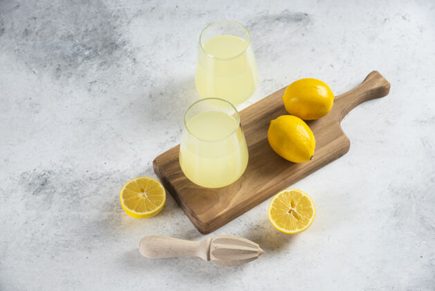 柠檬在木板上放两杯美味的柠檬水凉鸡尾酒马克杯