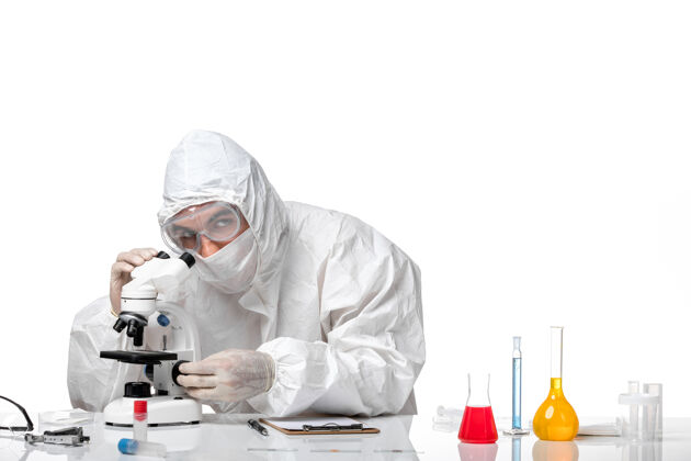 男医生正面图：男医生穿着防护服 戴着面罩 在空白处使用显微镜实验室外套套装防护